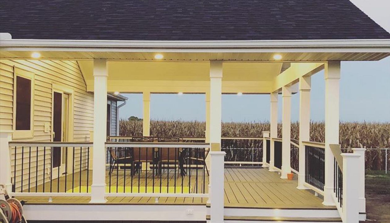 Side shot of a porch addition with soffit and stair lighting.
