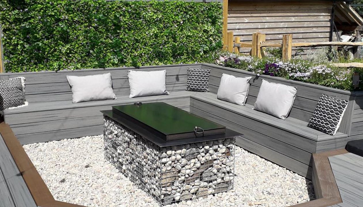 Project outline: Create an entertaining space with seats and a fire pit the customer opted for Island Mist Transcend deck plank with Toasted Sand Transcend border plank