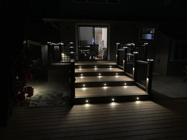 Trex Transcend Tiki Torch decking with Vintage Lantern boarder, Transcend Vintage Lantern railing with metal balusters and Trex lighting