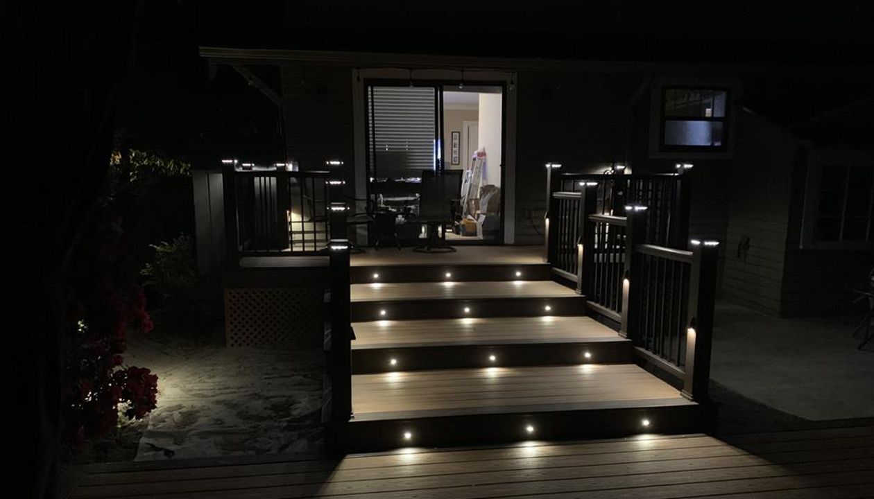 Trex Transcend Tiki Torch decking with Vintage Lantern boarder, Transcend Vintage Lantern railing with metal balusters and Trex lighting