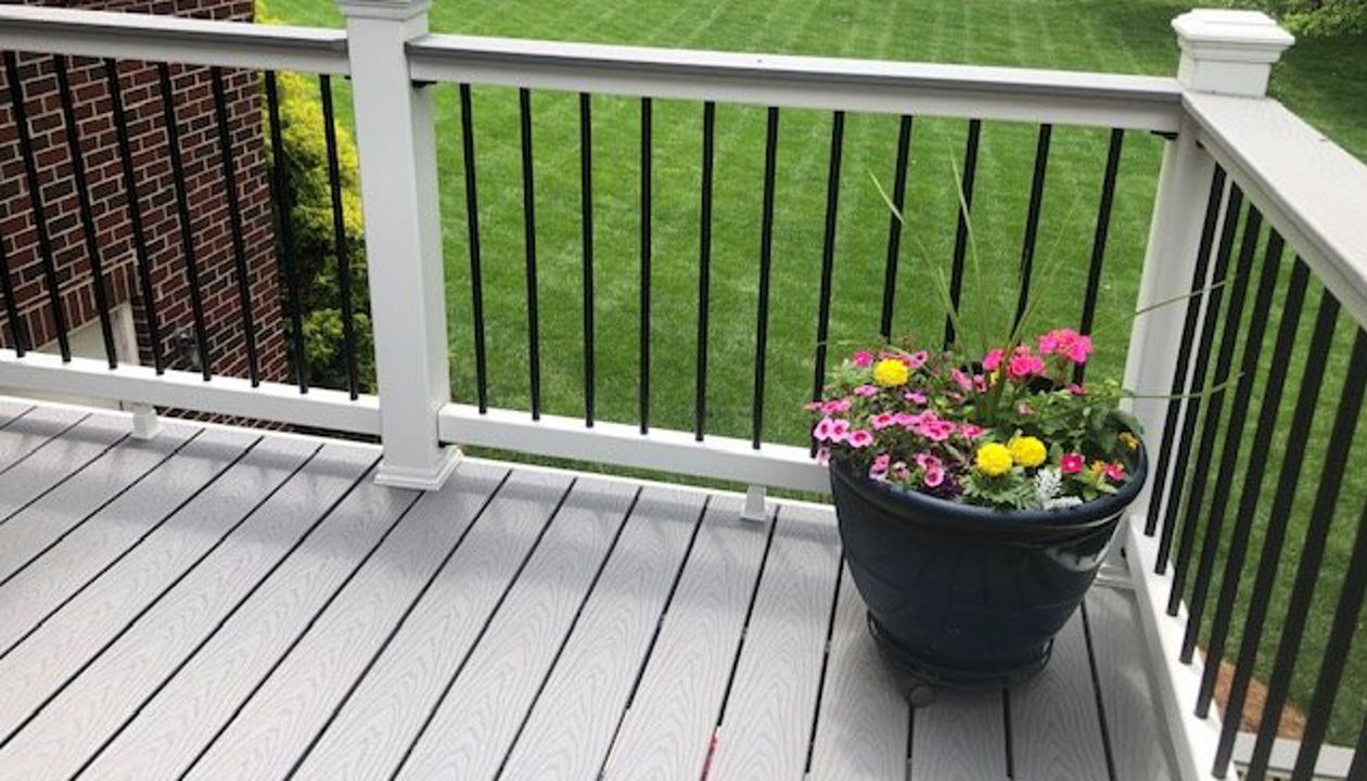 Trex Select Classic White handrailing with black aluminum balusters perserve the wonderful view in this backyard
