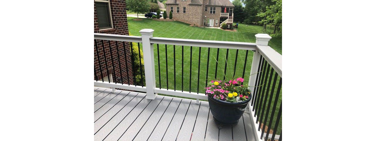 Trex Select Classic White handrailing with black aluminum balusters perserve the wonderful view in this backyard