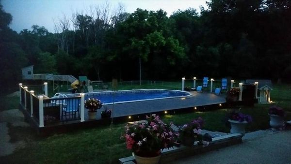 Beautiful pool deck with Trex Outdoor Lighting.  Trex Transcend Vintage Lantern decking with Spiced Rum accents.  Classic White &amp;amp;amp; Vintage Lantern Transcend railings in Council Bluffs, IA