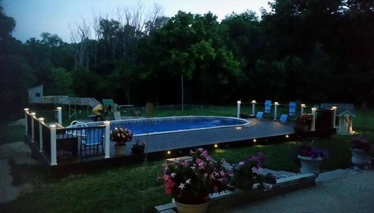 Beautiful pool deck with Trex Outdoor Lighting.  Trex Transcend Vintage Lantern decking with Spiced Rum accents.  Classic White &amp;amp;amp; Vintage Lantern Transcend railings in Council Bluffs, IA