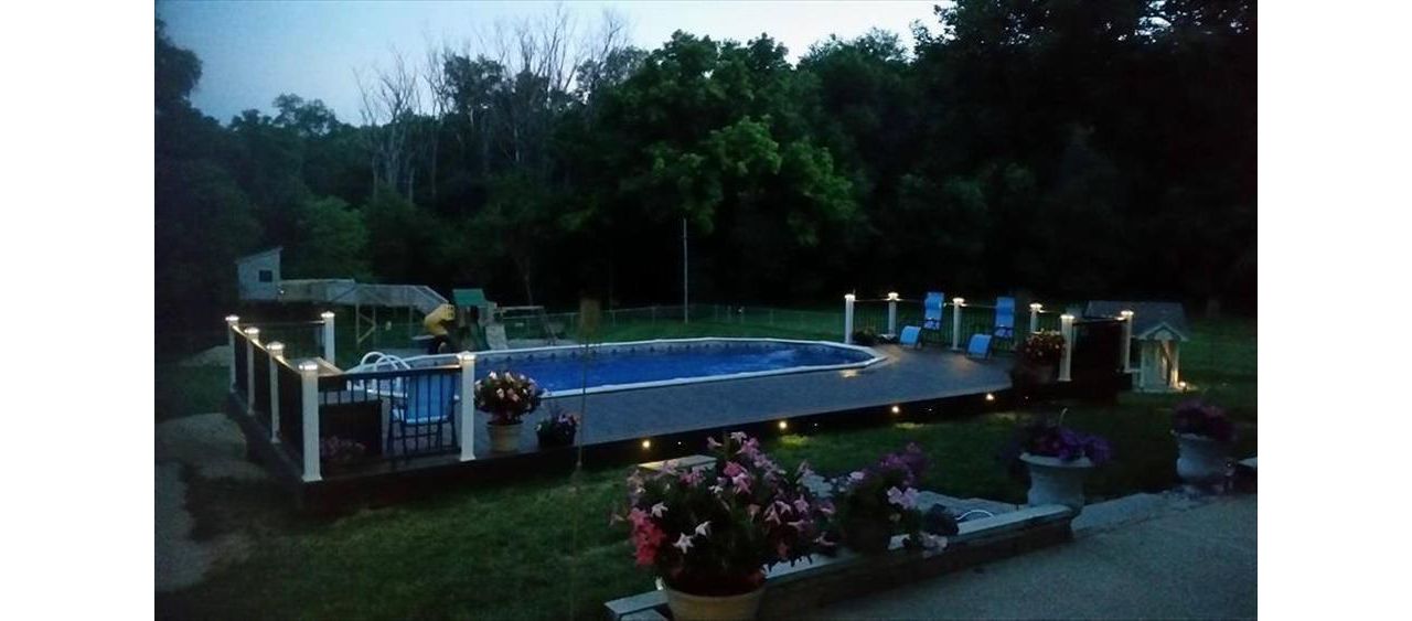 Beautiful pool deck with Trex Outdoor Lighting.  Trex Transcend Vintage Lantern decking with Spiced Rum accents.  Classic White &amp;amp;amp; Vintage Lantern Transcend railings in Council Bluffs, IA