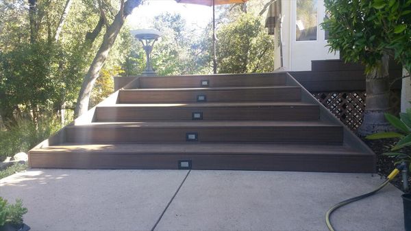 Custom Trex deck in Tiki Torch and Spiced Rum in Redding. Stairs have lighting and unique angles set to match the house. Majestic Builders is proud to provide top quality composite decks that will last a lifetime.