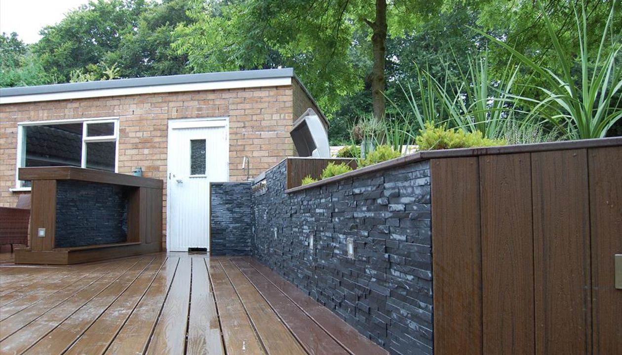 Large outdoor cooking and dining space in Lymm, Cheshire using Trex Transcend Vintage Lantern for the borders and upstands with Spiced Rum for the main deck area