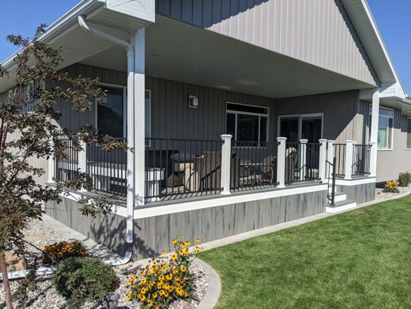 Island Mist Decking and Skirting, Black Iron Metal Rail and white Trex Posts.