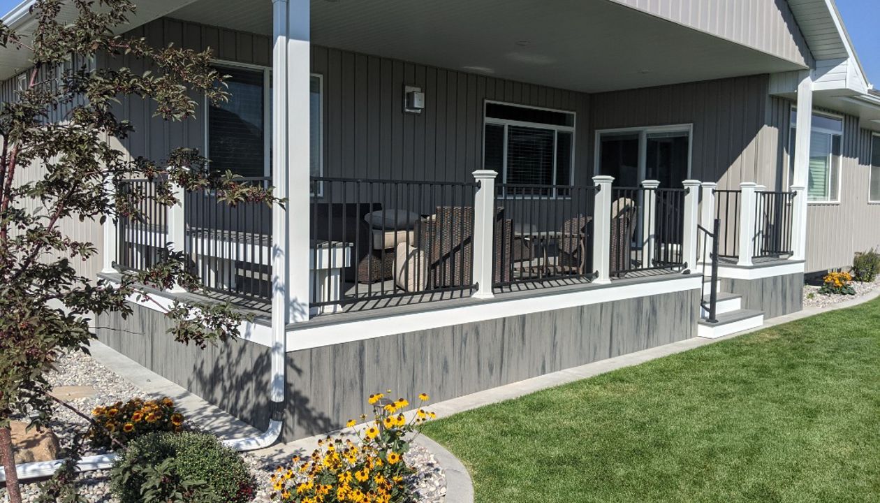 Island Mist Decking and Skirting, Black Iron Metal Rail and white Trex Posts.