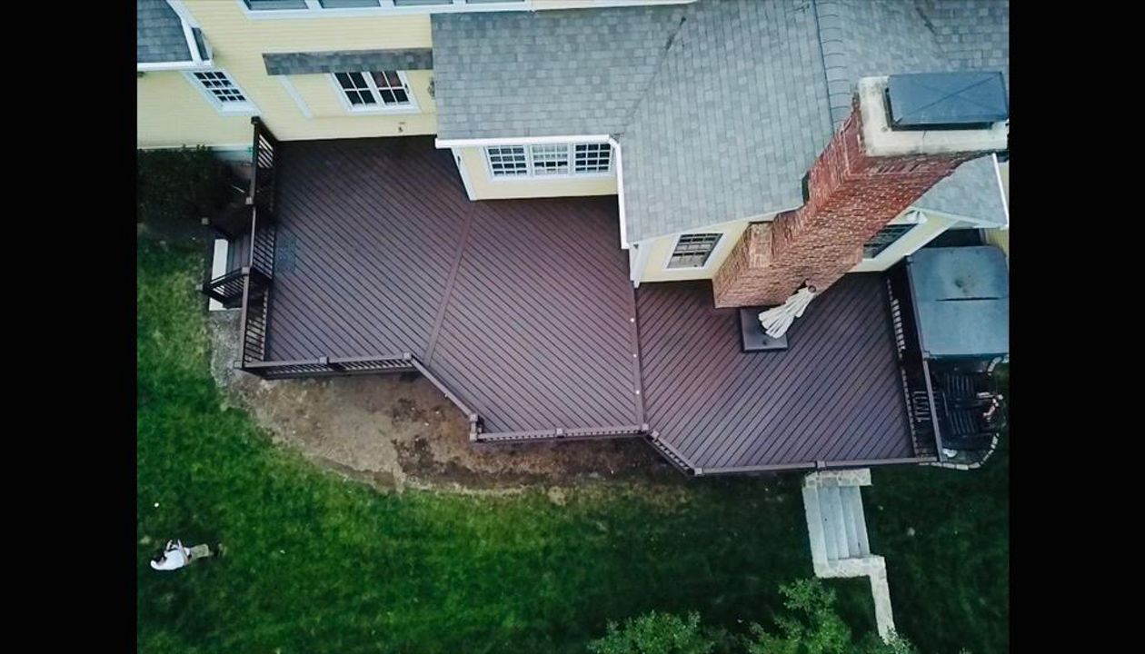 Trex Lava Rock Decking with Vintage Lantern Top/Bottom Rails and Bronze Aluminum Balusters. Custom Lattice with access gate for below deck storage. Post cap lights and riser lights in the stairs and step between tiers