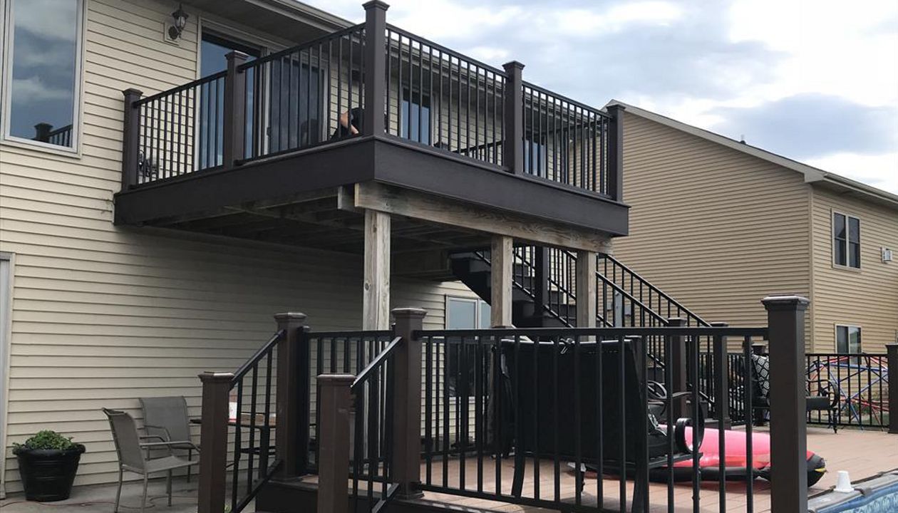 Trex Select Saddle with Woodland Brown accents and Signature black aluminum rails with lighting caps and riser lights by GE Contracting LLC