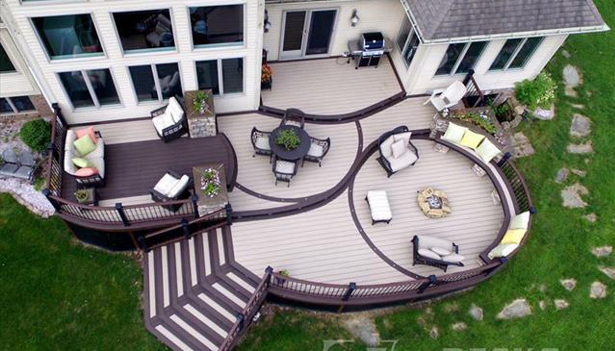 Show stopping TREX deck with all the main ingredients; curves, lighting, firepit, built in seating & planters, stone work, under deck storage, multi-levels, and flared staircase.