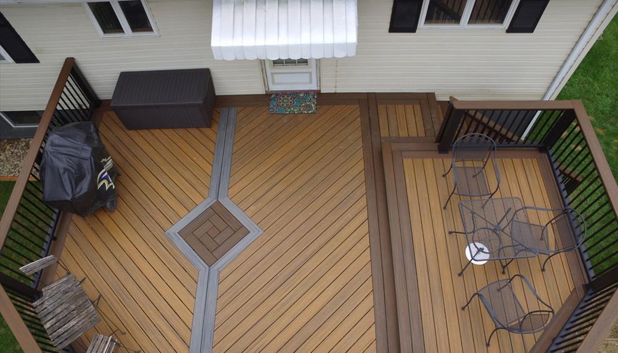 Trex Transcend deck w/ Spiced Rum, Havana Gold, and Island Mist inlay.  Finished off with square aluminum balusters and cocktail tops.