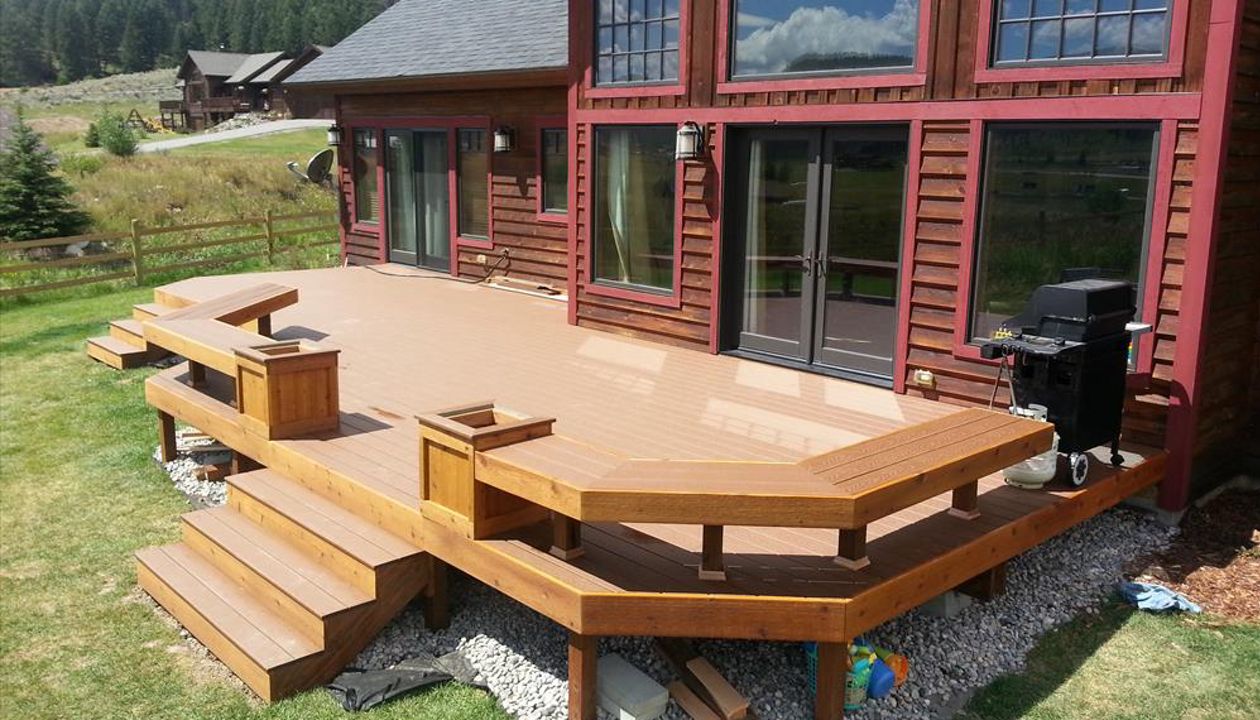 Rounded Deck, Big Sky, MT. Project completion. Built-in perimeter bench seating and planter boxes.