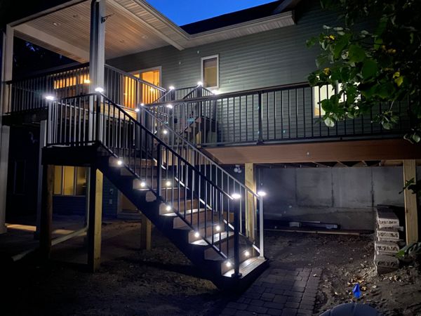 Two-Tone Low-Maintenance Trex Transcend Composite Deck with Black, Aluminum Railing and Featuring Low-Voltage, LED Lighting for Safety and Ambiance in the Rochester, MN Area built by Schmidt Carpentry, LLC