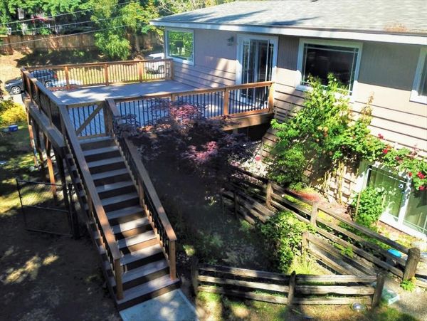 Trex Enhance Naturals Rocky Harbor with Toasted Sand accent and cedar rails with black aluminum pickets and a composite "cocktail" rail.