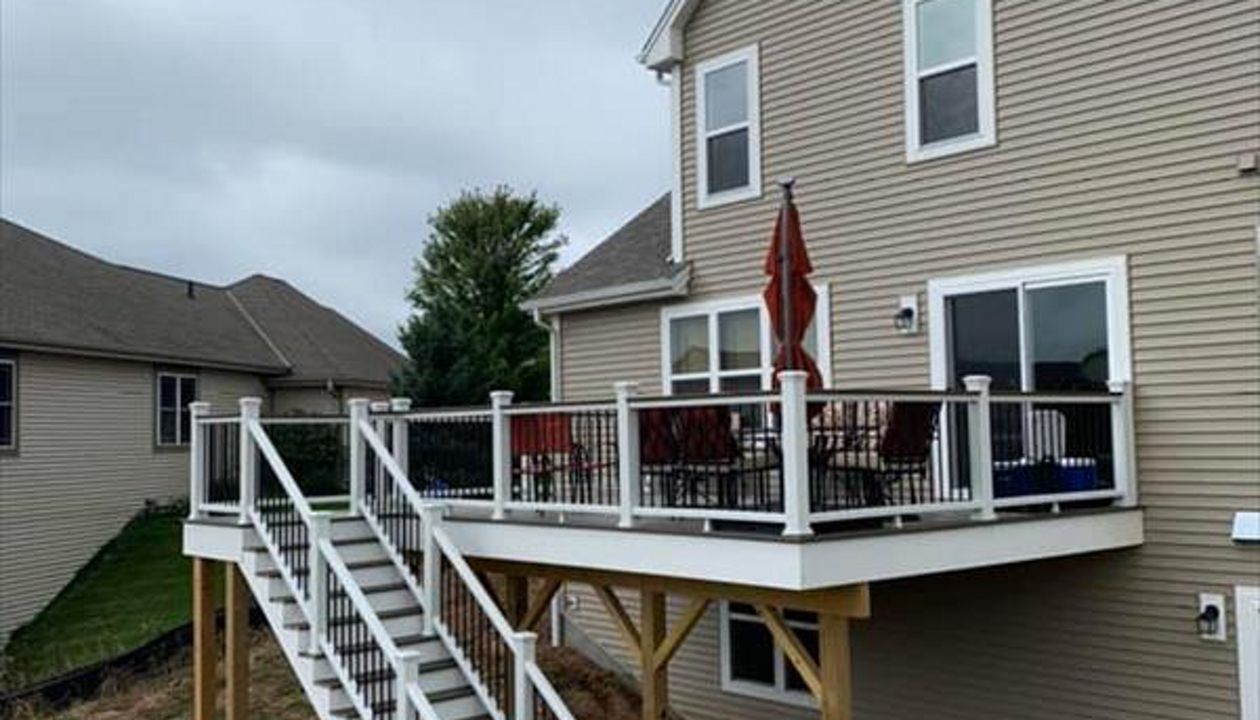 This deck feature Trex transcend white railing with black round aluminum ballusters. It has trex enhance rocky harbor decking and toasted sand picture frame. It has a toasted sand drink rail.