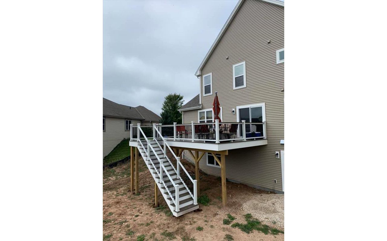 This deck feature Trex transcend white railing with black round aluminum ballusters. It has trex enhance rocky harbor decking and toasted sand picture frame. It has a toasted sand drink rail.