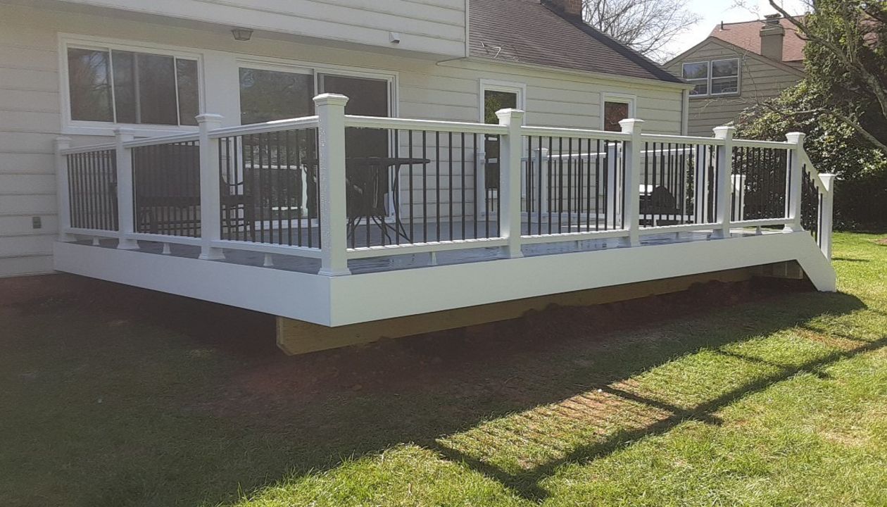 Transcend Classic White Railing. Black round aluminum balusters. TREX Select Pebble Grey decking