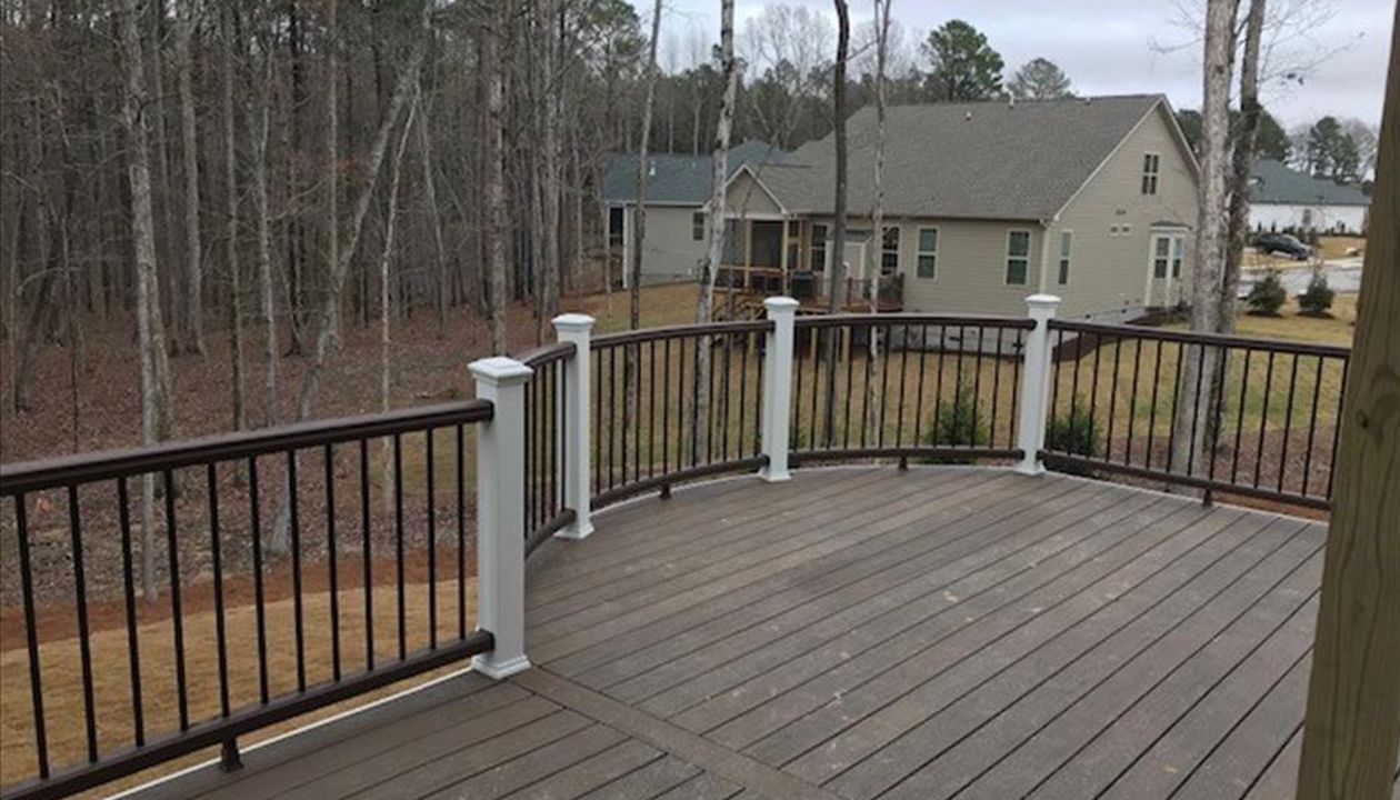 Custom Curved Trex Transcend Spiced Rum deck with Vintage Lantern railing with Classic White posts in Wake Forest, NC