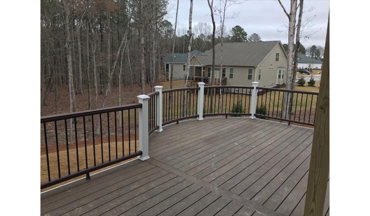 Custom Curved Trex Transcend Spiced Rum deck with Vintage Lantern railing with Classic White posts in Wake Forest, NC