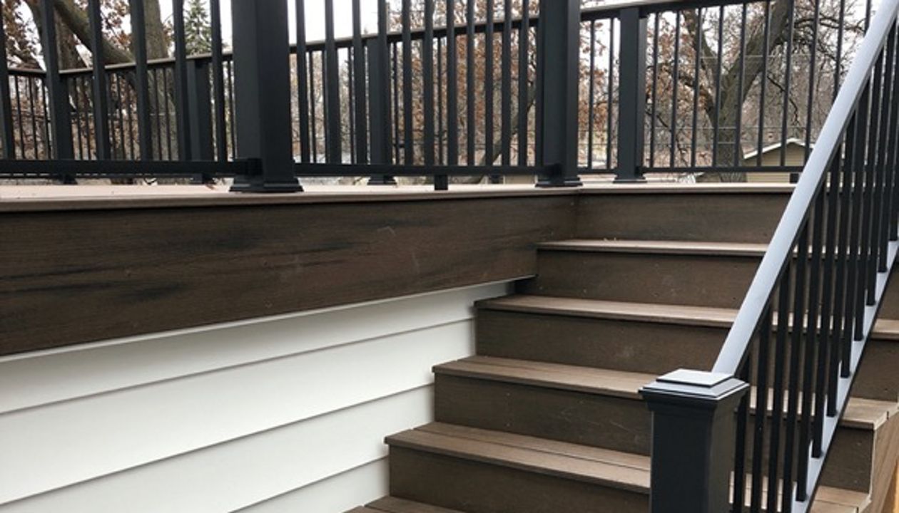 Trex/Transcend/Spiced Rum/Composite Decking with Trex/Signature/Aluminum Railing (black) between Trex Composite Post Sleeves and Trex/Transcend/Spiced Rum/Composite Decking for Cocktail Rail