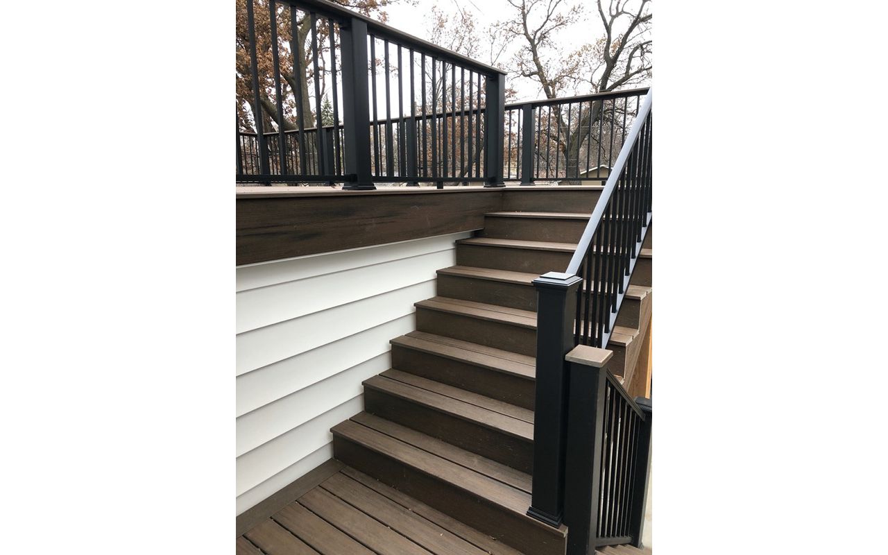 Trex/Transcend/Spiced Rum/Composite Decking with Trex/Signature/Aluminum Railing (black) between Trex Composite Post Sleeves and Trex/Transcend/Spiced Rum/Composite Decking for Cocktail Rail