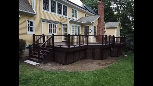 Angled view of Trex Transcends Lava Rock Decking with Lighting in stair risers and post caps and Brazilian Walnut Vinyl Privacy lattice with Trex Transcends Lava Rock Decking Picture Frame