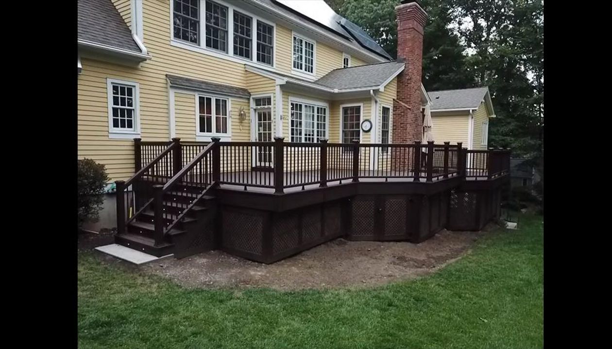 Angled view of Trex Transcends Lava Rock Decking with Lighting in stair risers and post caps and Brazilian Walnut Vinyl Privacy lattice with Trex Transcends Lava Rock Decking Picture Frame