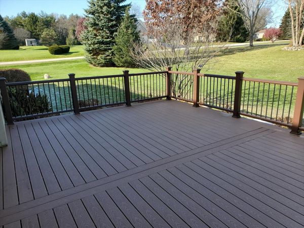 Trex Select decking with Transcend railing kits in Vintage Lantern with Black aluminum balusters compliment each-other on this deck restoration in McHenry, IL.