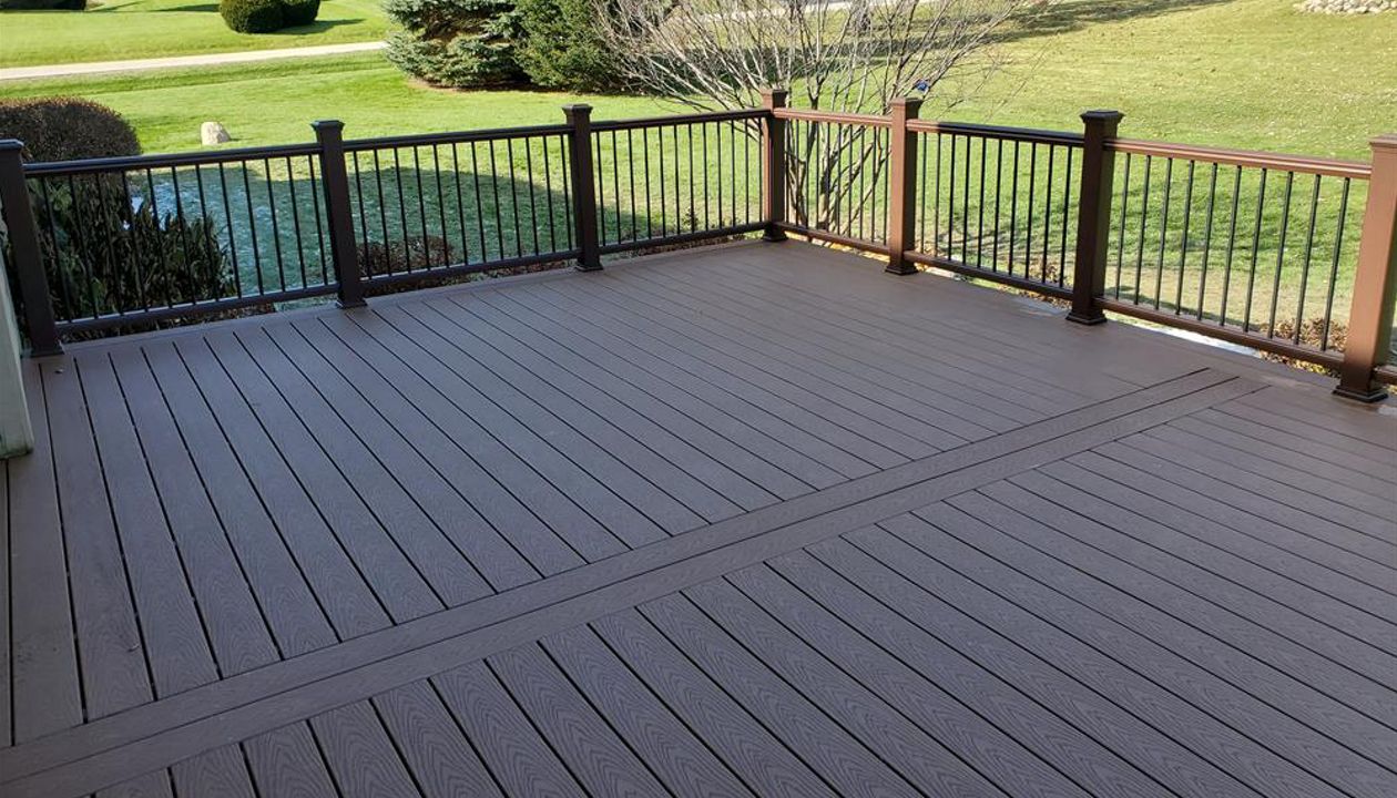 Trex Select decking with Transcend railing kits in Vintage Lantern with Black aluminum balusters compliment each-other on this deck restoration in McHenry, IL.