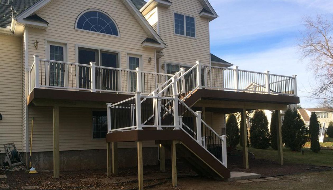 select Saddle decking, risers and fascia. Vinyl rail with black pipe balusters