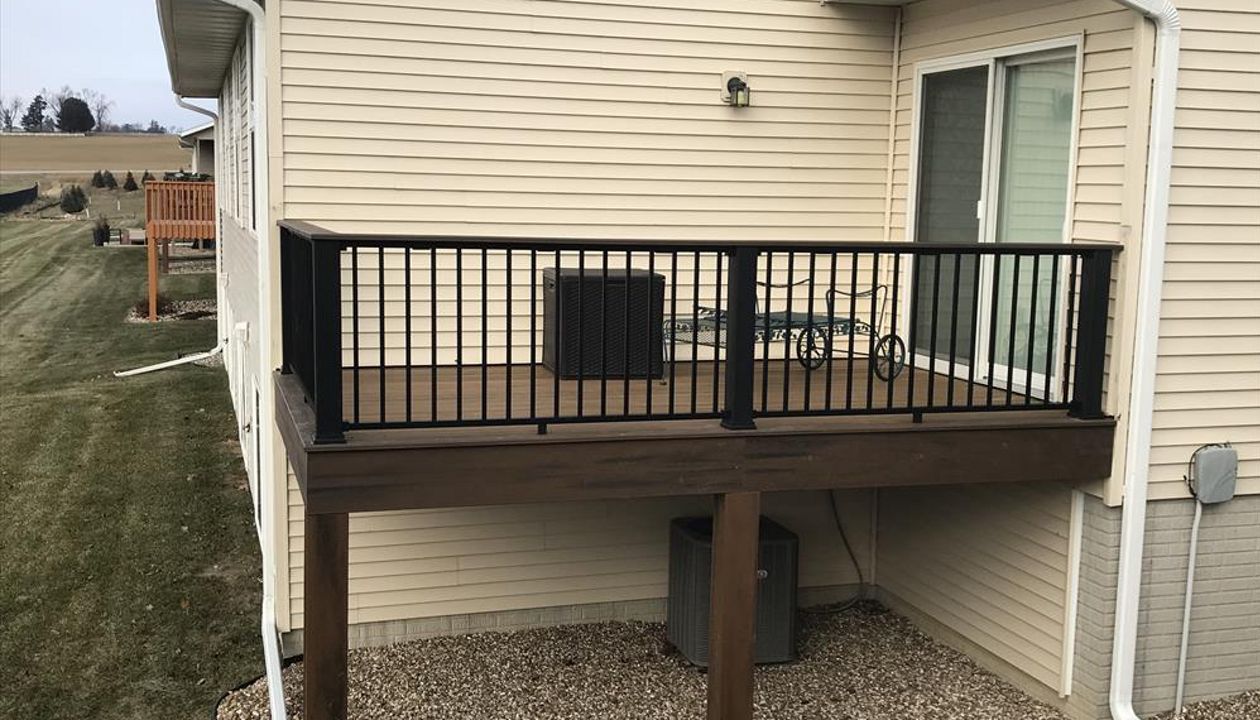 Trex Transcends Tropical Havana Gold Decking With Spiced Run Picture Framing, Trim, &amp; Accents; Black Signature Aluminum Railings With Black Transcends Rail Post Sleeves &amp; A Spiced Rum Colored Cocktail Drink Ledge To Match Fairfax Iowa