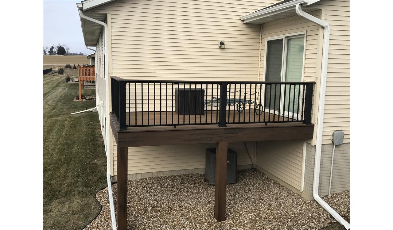 Trex Transcends Tropical Havana Gold Decking With Spiced Run Picture Framing, Trim, &amp; Accents; Black Signature Aluminum Railings With Black Transcends Rail Post Sleeves &amp; A Spiced Rum Colored Cocktail Drink Ledge To Match Fairfax Iowa