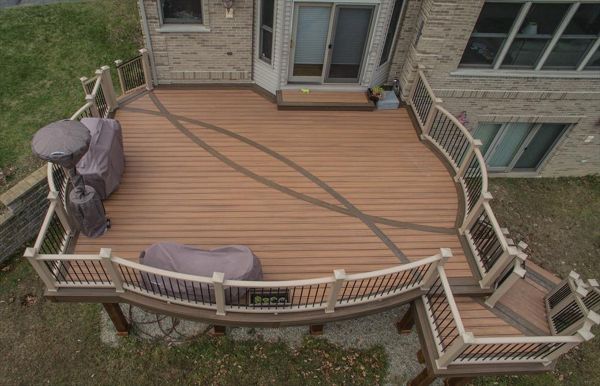 This second story deck in Brighton, MI is made up of Trex transcends tiki torch decking with a vintage lantern border. It has a custom curved rope swing rail and a custom curved inlay. Guarantee there isn't another deck out there like this one!