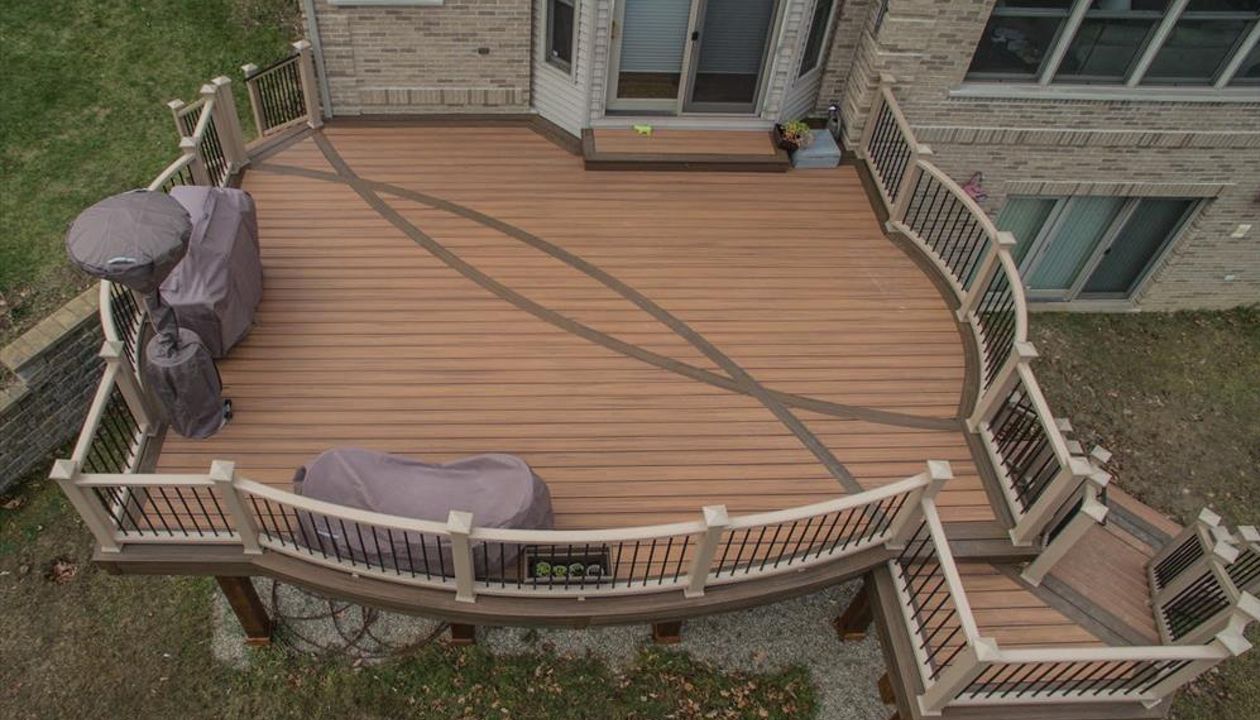 This second story deck in Brighton, MI is made up of Trex transcends tiki torch decking with a vintage lantern border. It has a custom curved rope swing rail and a custom curved inlay. Guarantee there isn't another deck out there like this one!