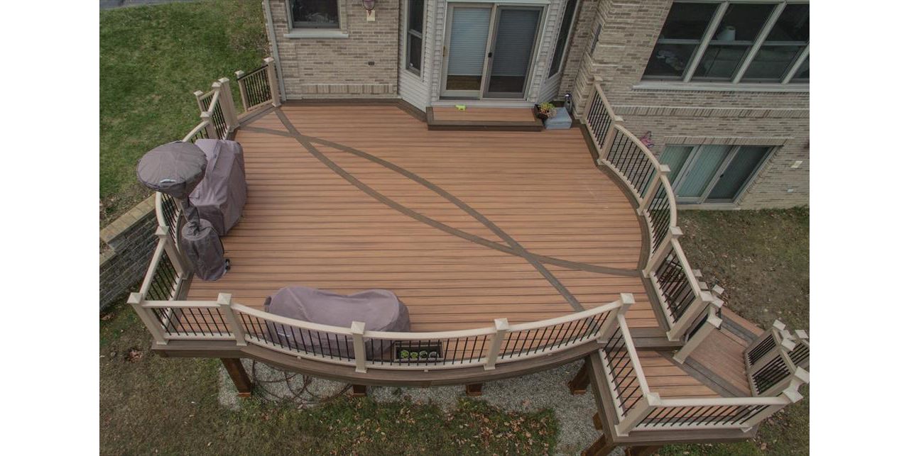 This second story deck in Brighton, MI is made up of Trex transcends tiki torch decking with a vintage lantern border. It has a custom curved rope swing rail and a custom curved inlay. Guarantee there isn't another deck out there like this one!