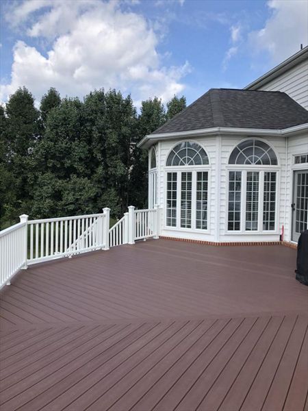 Deck in Trex Transcends Fire Pit and white Trex Transcends railing with square white balusters and pyramid post caps in Vienna