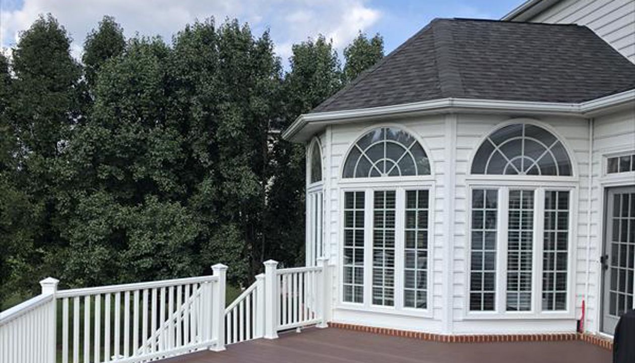 Deck in Trex Transcends Fire Pit and white Trex Transcends railing with square white balusters and pyramid post caps in Vienna