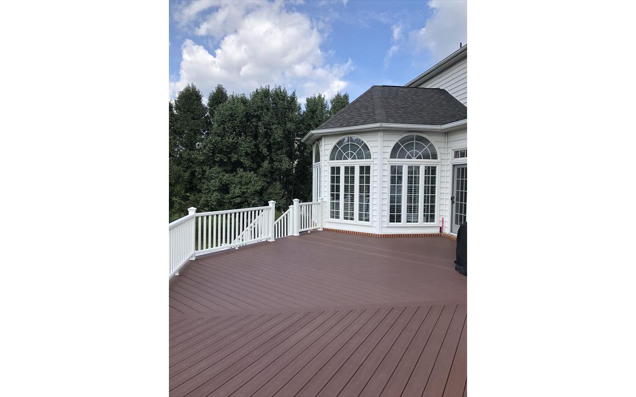 Deck in Trex Transcends Fire Pit and white Trex Transcends railing with square white balusters and pyramid post caps in Vienna