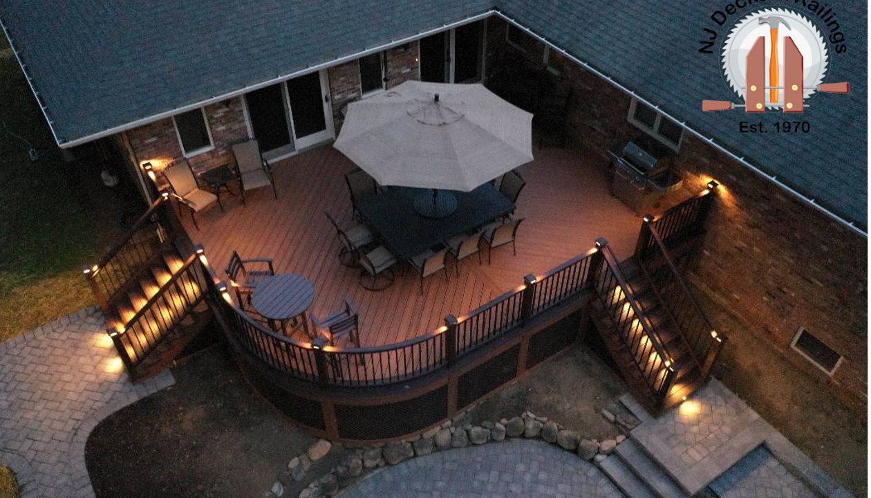 Curved deck with Tiki Torch decking, Lava Rock border and treads, Vintage Lantern railings with black aluminum balusters, post cap and riser lights