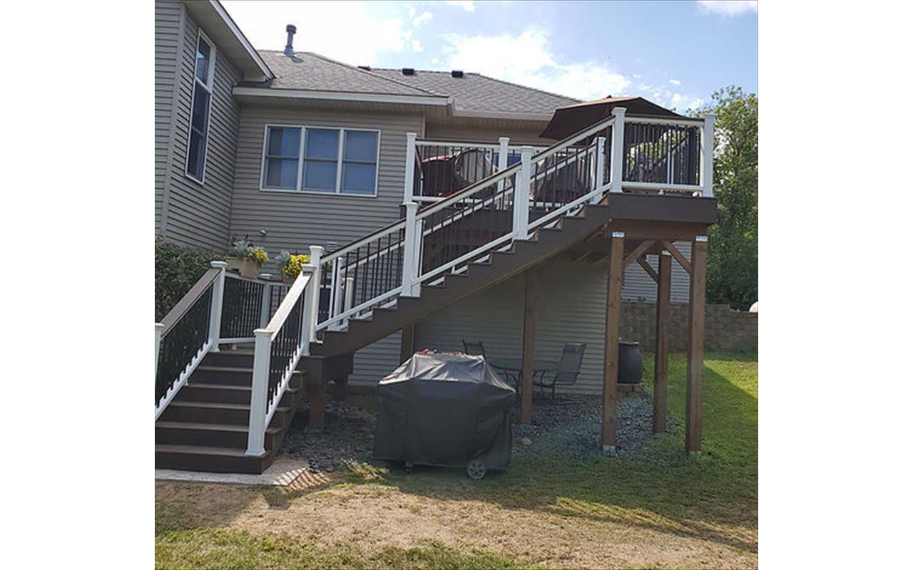 Trex Transcend Decking and Railing. Decking is Spiced Rum and the Railing is Classic White with Black, Aluminum Balusters and a Spiced Rum Deck Board Drink Rail on top of the Railing