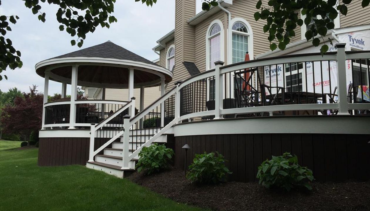 Classic white-railed deck with steps leading to a covered outdoor area.