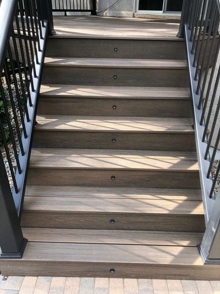 Trex/Transcend/Spiced Rum Composite Decking with Trex/Transcend Universal Composite Railing (black with round aluminum balusters) and Trex/Transcend Spiced Rum Composite Decking with Trex Stair Accent Lighting