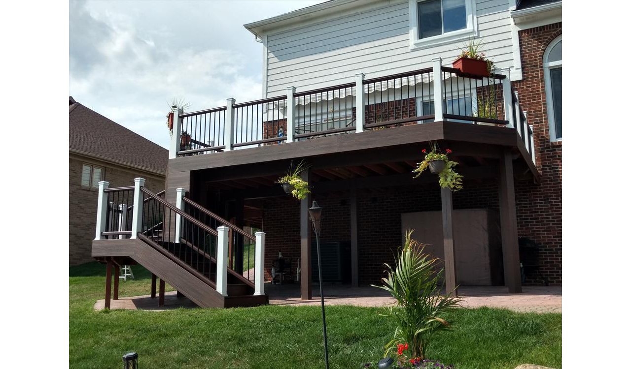 Redeck project after. Lava rock decking and facia, Vintage lantern top and bottom rails, black balusters, and white posts with white lighted post caps.,