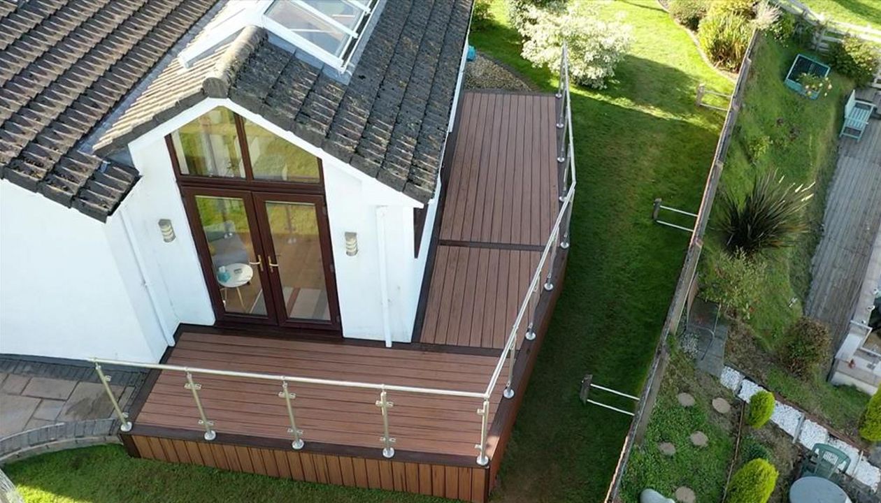 Trex Transcend Tiki Torch field with Larva Rock boarder with Stainless steel and glass railing fitted at Swansea