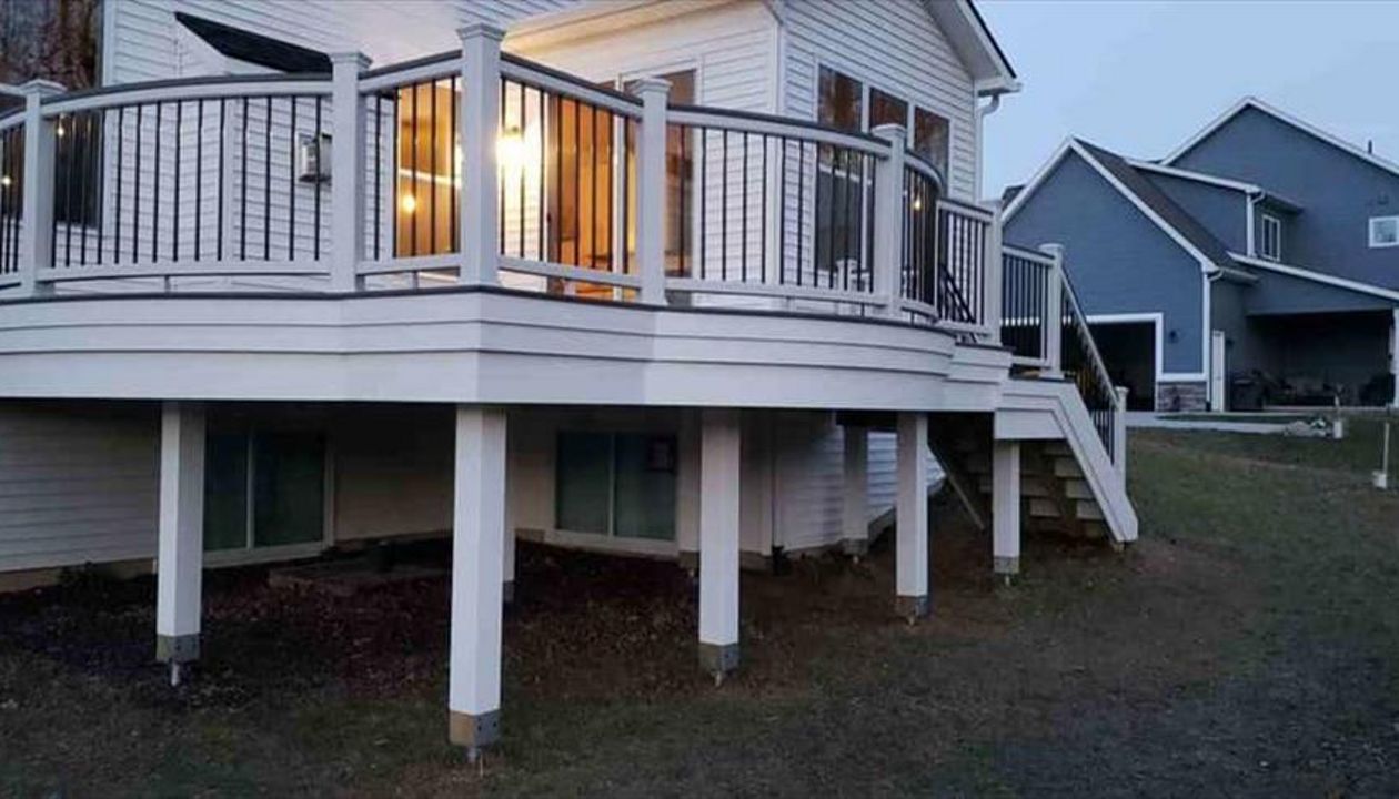 Trex Transcends island mist curved decking with white trex transcends curved rail. Goliath Tech helical piers. This beautiful deck is located in South Lyon, MI.