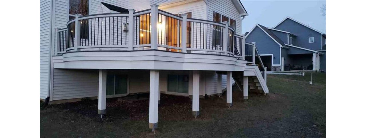 Trex Transcends island mist curved decking with white trex transcends curved rail. Goliath Tech helical piers. This beautiful deck is located in South Lyon, MI.
