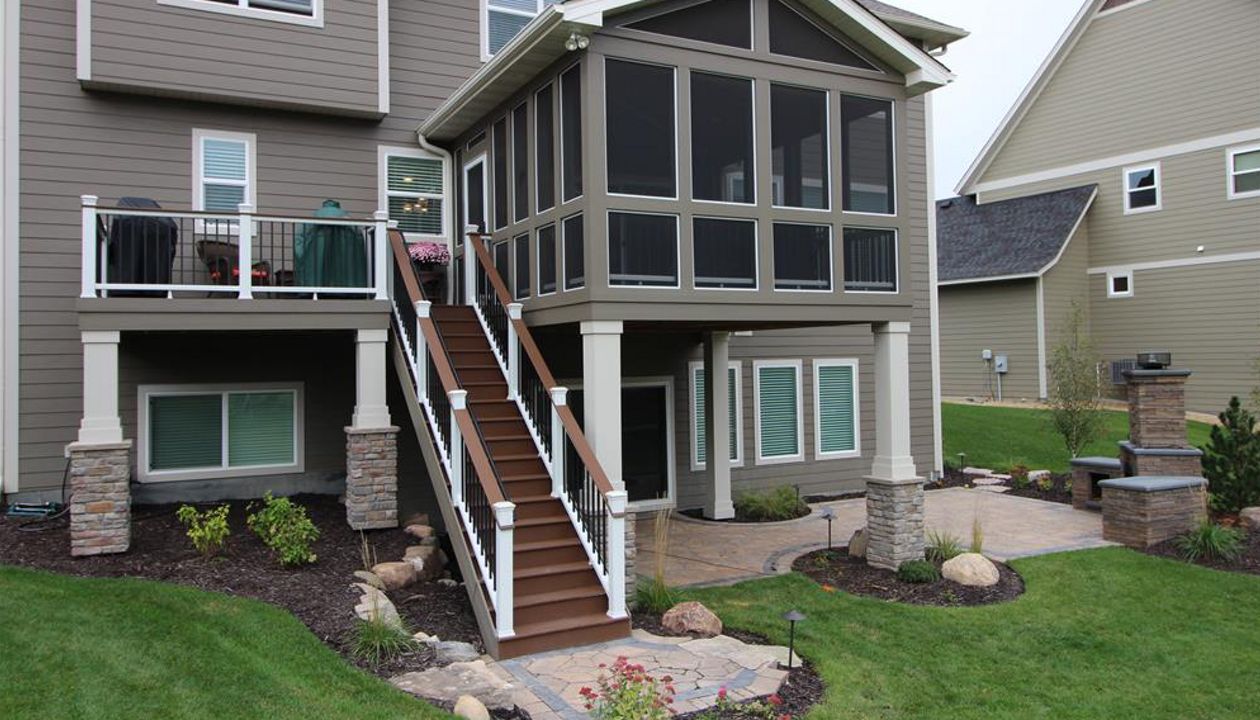 Trex decking, fascia, and risers in Saddle with Trex Transcend railing in white with a drink rail in Saddle - Plymouth