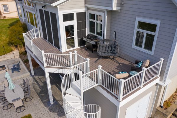 Trex Enhanced Rocky Harbor decking with white Trex Signature railing and Trex spiral stairs